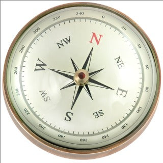 Circular compass finished in brass. Major directions are marked and degrees surround the outer edge