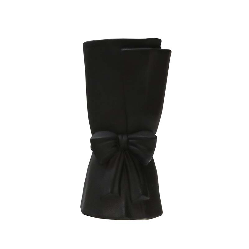 Black coloured vase in shape of a bow wrapped around fabric