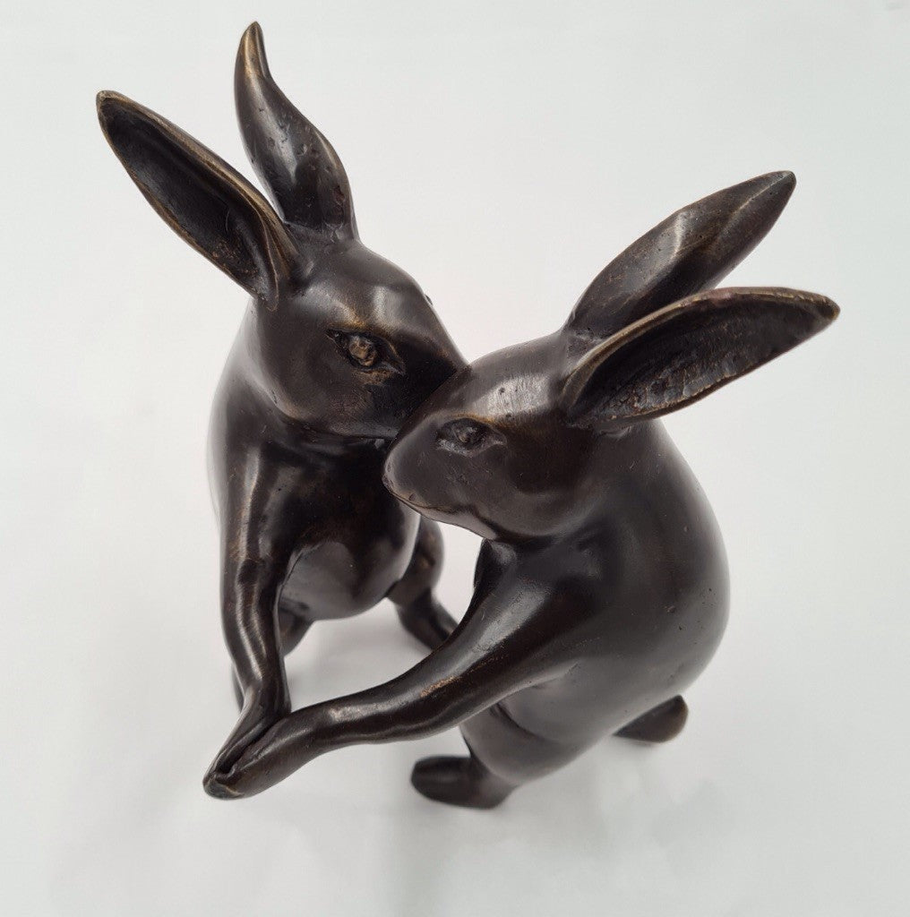 Two bunny ornaments dancing together.