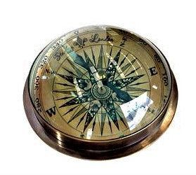 Domed compass finished in brass, it has an ornate face with major directions marked and degrees surrounding the outer edge. 