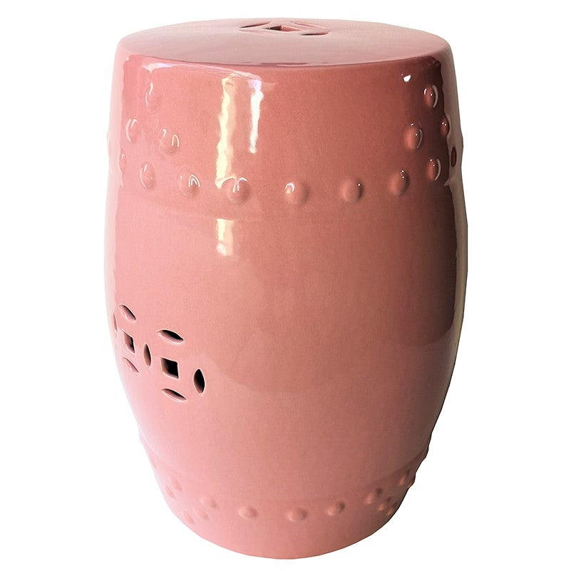 Pink coloured barrel-shape ceramic stool with cutouts.