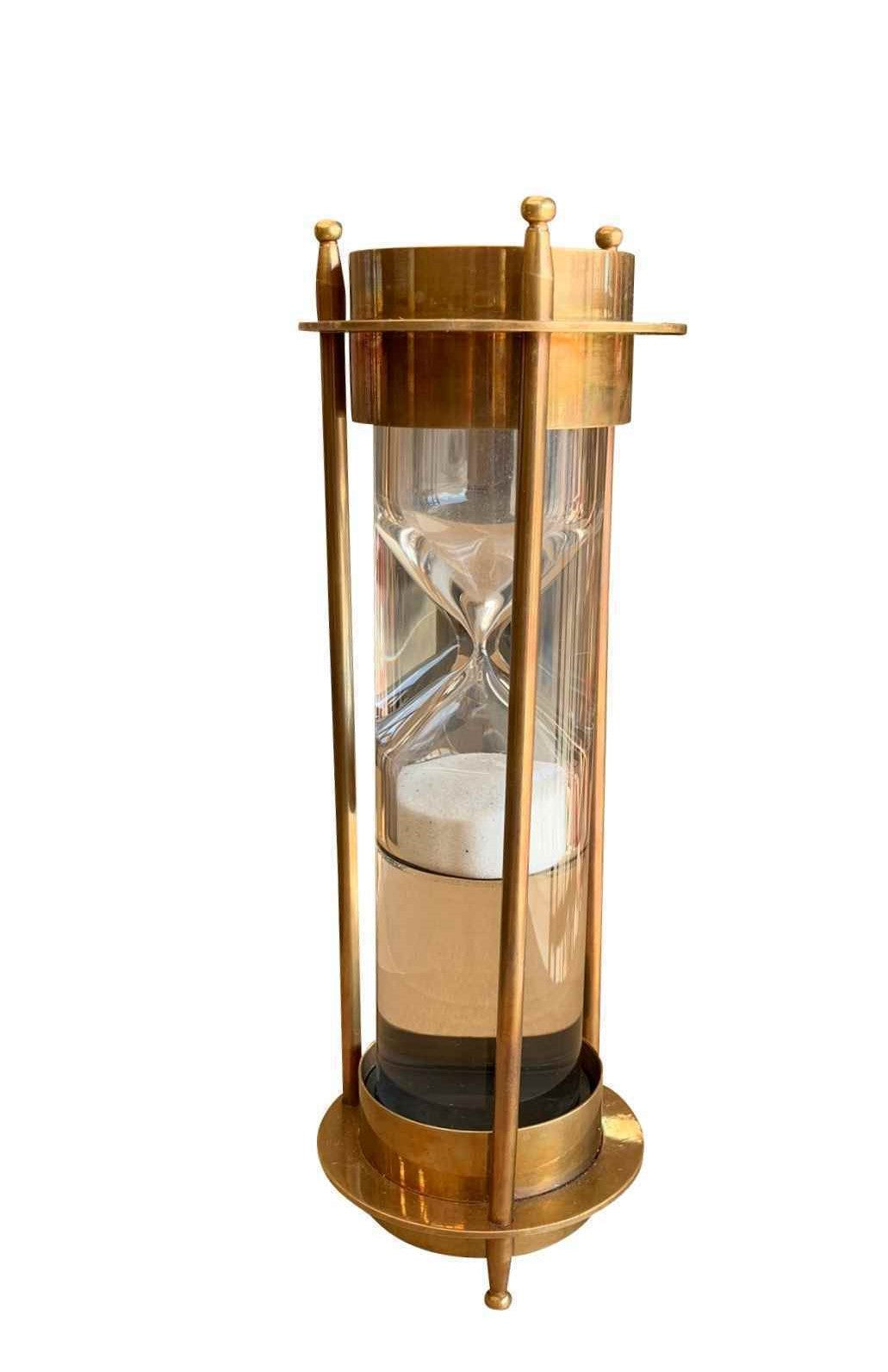 Upright hourglass sand timer finished in brass. Each end contains a compass.